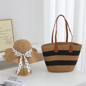 Detailed view of summer straw sun hat with polka dot ribbon and striped beach tote bag set.