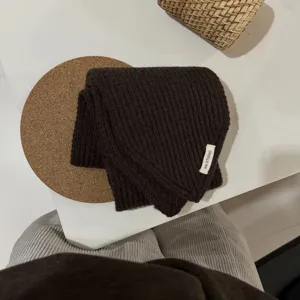 Detailaufnahme eines dunkelbraunen gerippten Strickschals, elegantes und weiches Winteraccessoire.