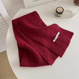 Dettaglio sciarpa invernale in maglia rossa, morbida lana per calore e moda quotidiana.