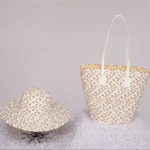 Detail view of woven straw tote bag and matching sun hat set, casual beach vacation style.