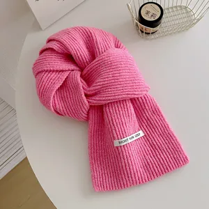 Accogliente sciarpa invernale in maglia rosa, morbida consistenza di lana per dettaglio.