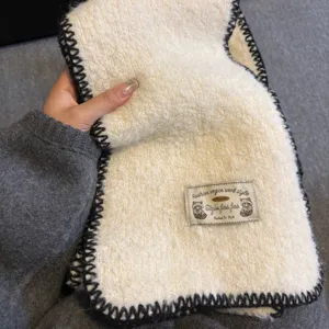 Cozy winter knitted wool scarf in off-white with black edge stitching and cute animal label.