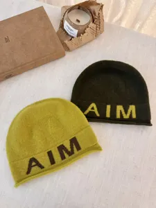 Close-up view of stylish wool knit beanie hat with letter embroidery, cozy winter fashion item.