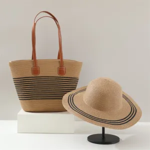 Woven straw tote bag and sun hat set, summer beach style with black stripes and brown handles.