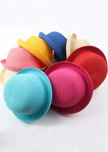 Gros plan détaillé de chapeaux de paille colorés avec bords roulés et design de dôme.