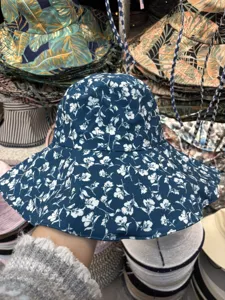 Detailansicht des blauen Blumen-Fischerhuts mit zartem weißem Blumenmuster und breiter Krempe.