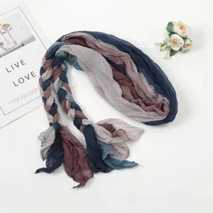 Detailed close-up of a multi-color braided fashion scarf flat lay with floral props.