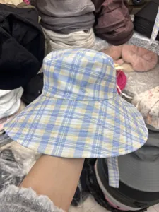 Blue and yellow plaid bucket hat detail showing the wide brim and soft cotton fabric texture.