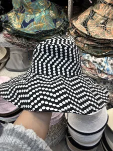 Detailansicht eines stylischen schwarz-weißen Pünktchen-Hutes mit breiter Krempe für Sommertage.