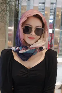 Detailed close-up of a stylish multi-color gradient braided headscarf for women.