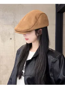 Close-up detail of the brown suede flat cap, stylish autumn winter headwear for women.