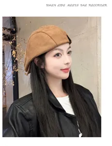 Close-up detail of stylish brown suede newsboy cap worn by model in autumn style outfit.