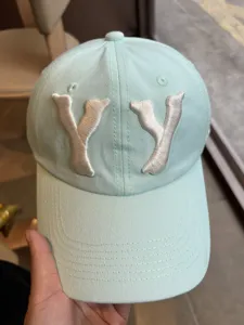 Close-up of mint green dad hat with white YY embroidery detail showing front craftsmanship.