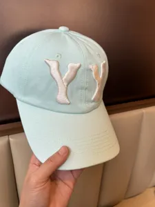 Detail shot of mint green washed baseball cap with white YY embroidery closeup view showing texture.