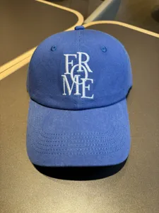 Blue baseball cap with white letter embroidery, soft top casual hat detail for everyday wear.