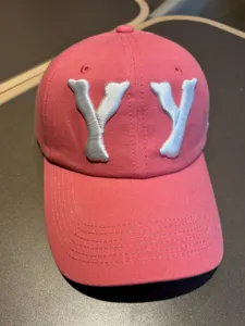 Pink washed vintage baseball cap with silver embroidered YY letters front detail view.