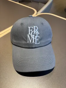 Detail shot of a dark grey Korean style casual baseball cap with white embroidered lettering.