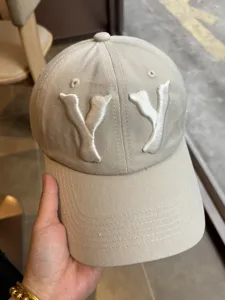 Close-up detail of the beige washed baseball cap featuring front 3D embroidered YY letters.