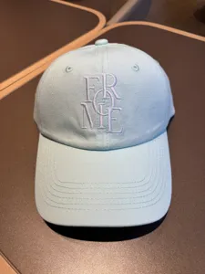 Detailed view of light blue cotton baseball cap with stylish front embroidered lettering.