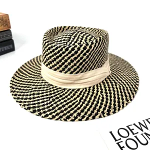 Detailed view of the French style black and white woven fedora hat with a beige fabric band.