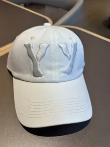 Detailed view of the white washed distressed baseball cap with embroidered YY letters.