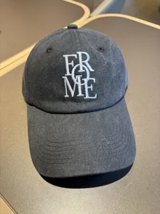 Classic washed black baseball cap with white embroidered lettering, soft top casual hat for daily wear.