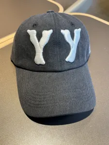 Washed distressed baseball cap featuring bold white YY letter embroidery for a trendy street look.