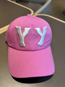 Detail view of the pink washed distressed baseball cap with silver embroidered YY letters.