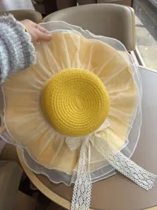 Eleganter gelber Sonnenhut mit weißer Gaze und Spitzenschleife, ideal für Sommerurlaub.
