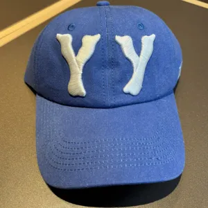 Blue washed cotton baseball cap featuring white embroidered YY letters, classic front view.