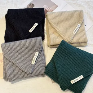 Detail view of soft knitted winter scarves in multiple colors, featuring a cozy textured fold.