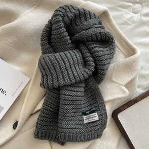 Detailed view of the cozy grey knitted winter scarf texture, soft wool blend fabric.