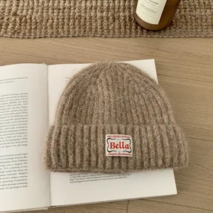 Knitted beanie hat for women, winter warm woolen cap with stylish patch design for casual wear.