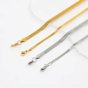 Detail view of minimalist stainless steel herringbone snake chain necklaces in gold and silver.