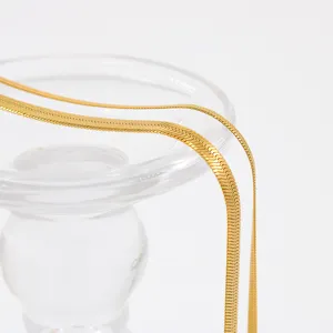 Minimalist stainless steel flat herringbone snake chain detail shot, elegant gold choker necklace.