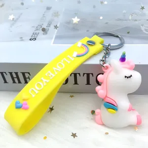 Cute cartoon unicorn keychain with vibrant yellow rainbow strap, perfect bag pendant detail shot.