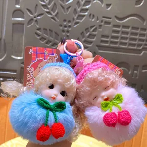 Close-up van schattige pluche pop sleutelhanger met fluffy bal en kersen decoratie voor tas.