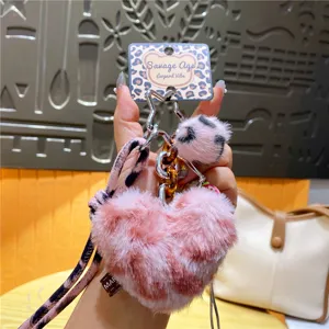 Detail roze luipaard print hart pluche sleutelhanger, fluffy pompon tas hanger en auto accessoire.