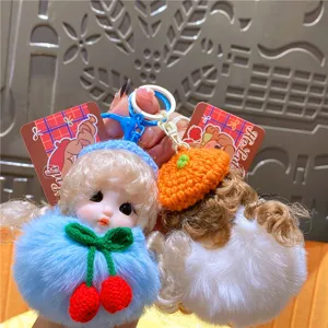 Gedetailleerd uitzicht op de schattige pluche poppensleutelhanger en pluizige tassenhanger.