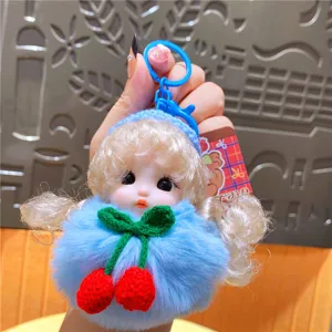 Schattige pluche pop sleutelhanger voorzien van blauwe pompon en gehaakte kersen hanger.