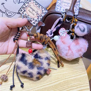 Detail luipaard print pluche hart sleutelhanger, pluizige charm met lederen bandje en slot.