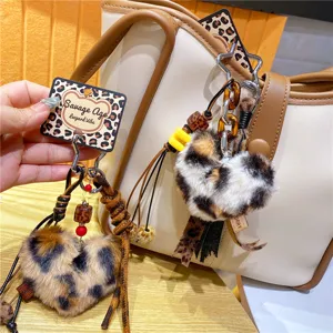 Detail van luipaard print pluche hart sleutelhanger, pluizige tas charm en auto accessoire.