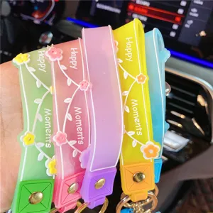 Kleurrijke siliconen sleutelhanger set met bloemenreliëf en happy moments tekst detailweergave.