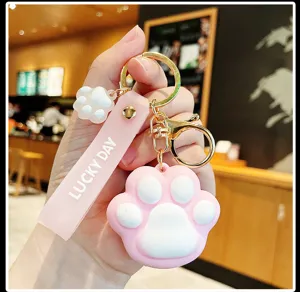 Cute pink silicone cat paw keychain with gold metal ring, stylish accessory for bags.