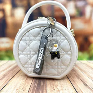 Modische weiße gesteppte Handtasche mit niedlichem Astronauten Flüssigkeit Schlüsselanhänger.