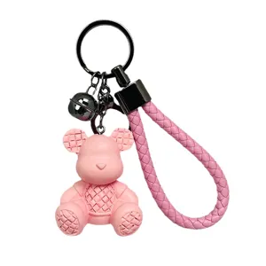 Simpatico portachiavi orsetto intrecciato rosa con cinturino per chiavi e borse.