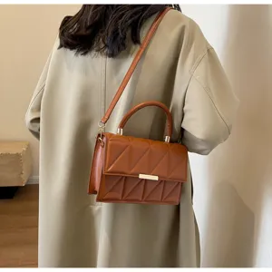 Detailed view of the brown quilted PU leather square shoulder bag with metal accent and handle.