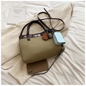 Retro PU leather shoulder bag detail showing contrast color design and twist lock hardware.