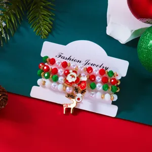 Dettaglio di quattro braccialetti natalizi con perline e ciondoli di Babbo Natale.