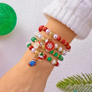 Dettaglio di un set di bracciali natalizi con perline e ciondoli a tema Babbo Natale
